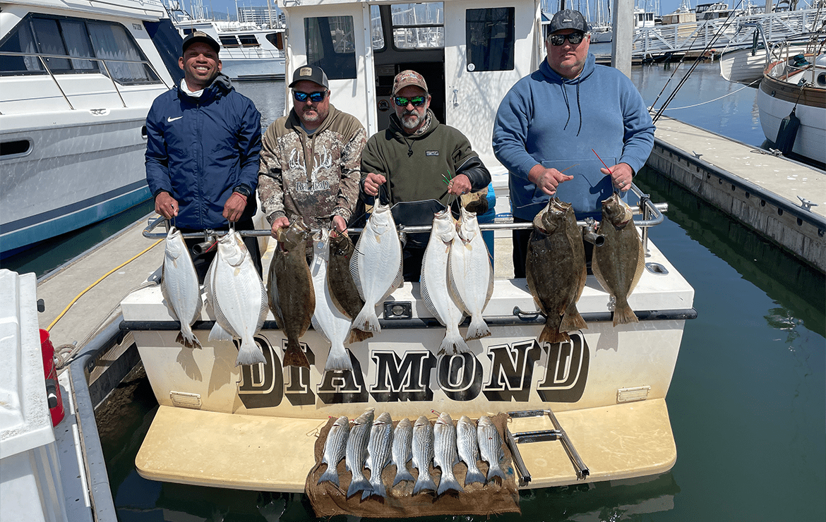Four Men Holding Fishes